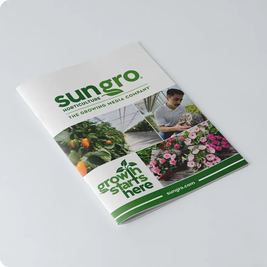 Sungro catalog brochure on white surface displaying greenhouse crops, nursery worker with media and pink flowering plants